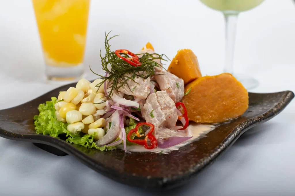 Peruvian Cuisine Guide: The Most Iconic Dishes and Drinks You Must Try 4 Traditional Peruvian ceviche served with sweet potato, choclo, lettuce, ají limo, and red onion.