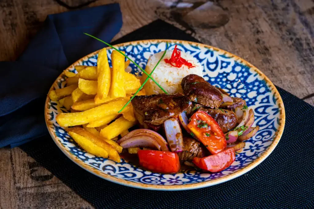 Peruvian Cuisine Guide: The Most Iconic Dishes and Drinks You Must Try 5 Traditional Peruvian Lomo Saltado served with stir-fried beef, onions, tomatoes, French fries, and rice.