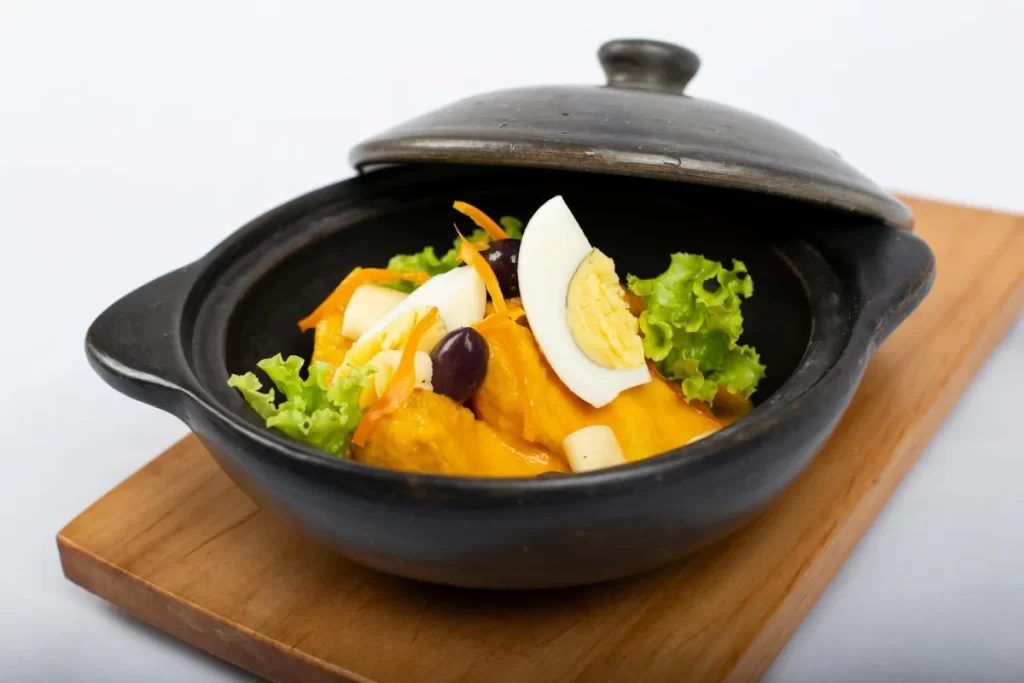 Peruvian Cuisine Guide: The Most Iconic Dishes and Drinks You Must Try 6 Peruvian Papa a la Huancaína served with yellow potatoes covered in creamy cheese sauce, lettuce, boiled eggs, and olives.