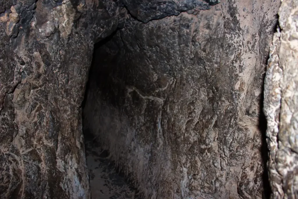 Inside the Inca Chinkana in Cusco (2025): Breakthrough Excavations Beneath Sacsayhuamán 11 Inner stone passageway of the Small Chinkana (Chinkana Chica) at Sacsayhuamán in Cusco, showing the narrow carved tunnel illuminated from inside.