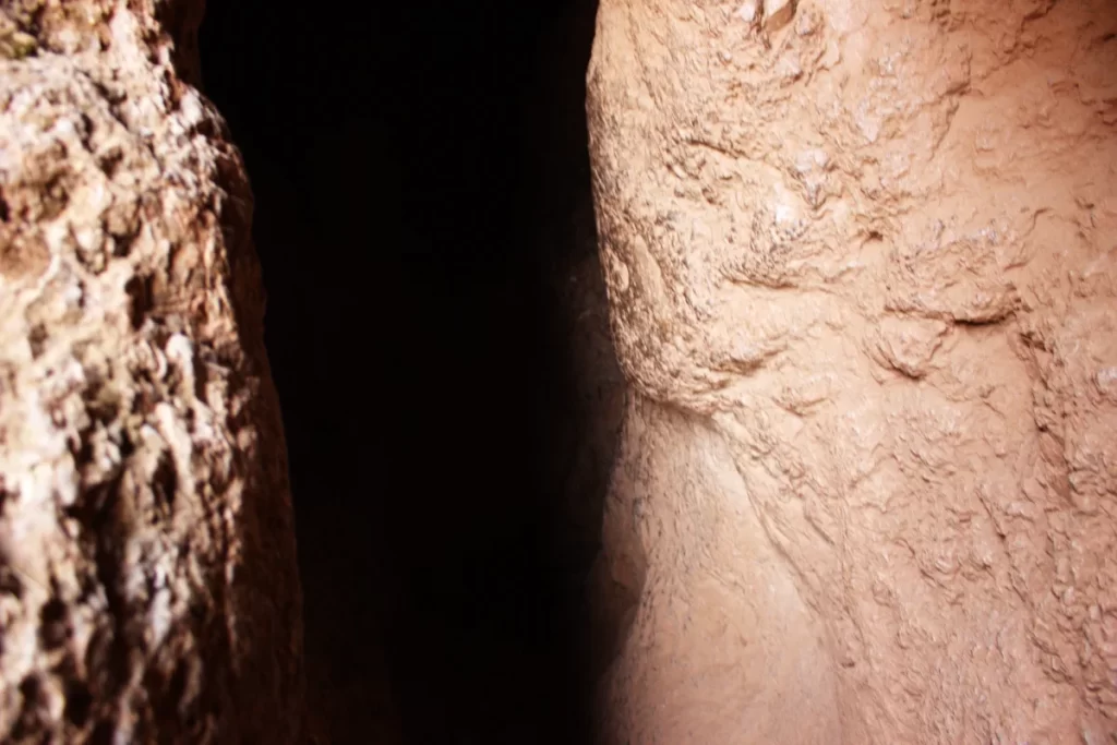 Inside the Inca Chinkana in Cusco (2025): Breakthrough Excavations Beneath Sacsayhuamán 10 View from inside the entrance of the Small Chinkana tunnel at Sacsayhuamán, showing illuminated rock walls and a darker central passage leading into the underground interior.