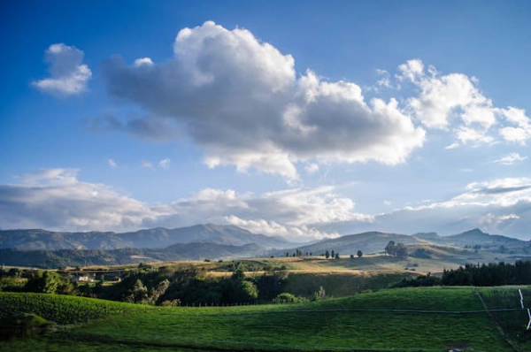 Rolling green landscapes in Boyacá, Colombia beneath dramatic clouds and Andean mountains