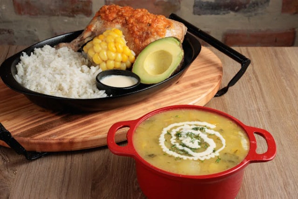 Traditional Colombian food with ajiaco soup chicken rice avocado and corn during a Medellín cultural and gastronomy experience